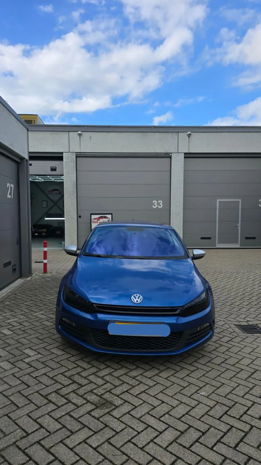 Blauwe Volkswagen met blauw reflecterende chameleon voorruitfolie
