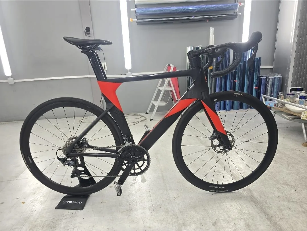Racefiets met zwarte frame en rode details in de werkplaats