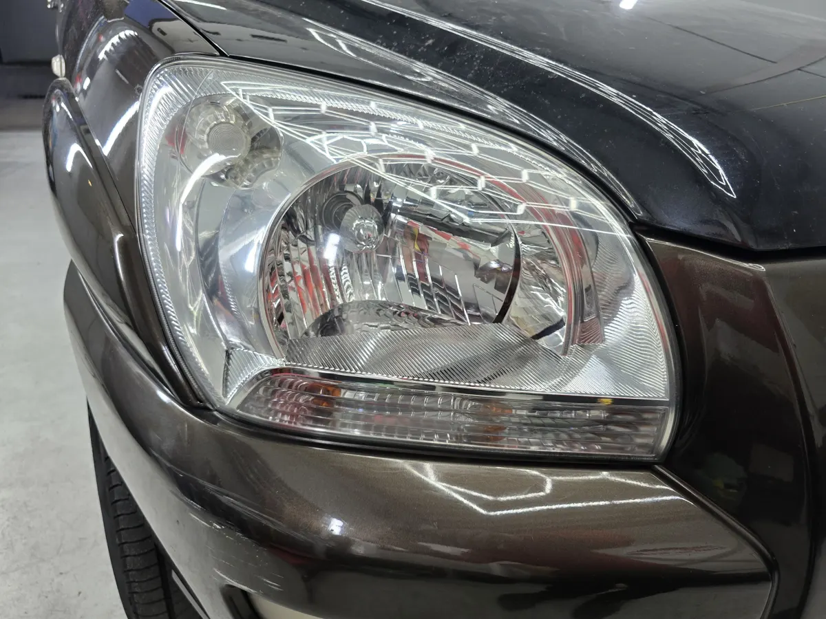 Gepolijste heldere koplamp van een donkere auto
