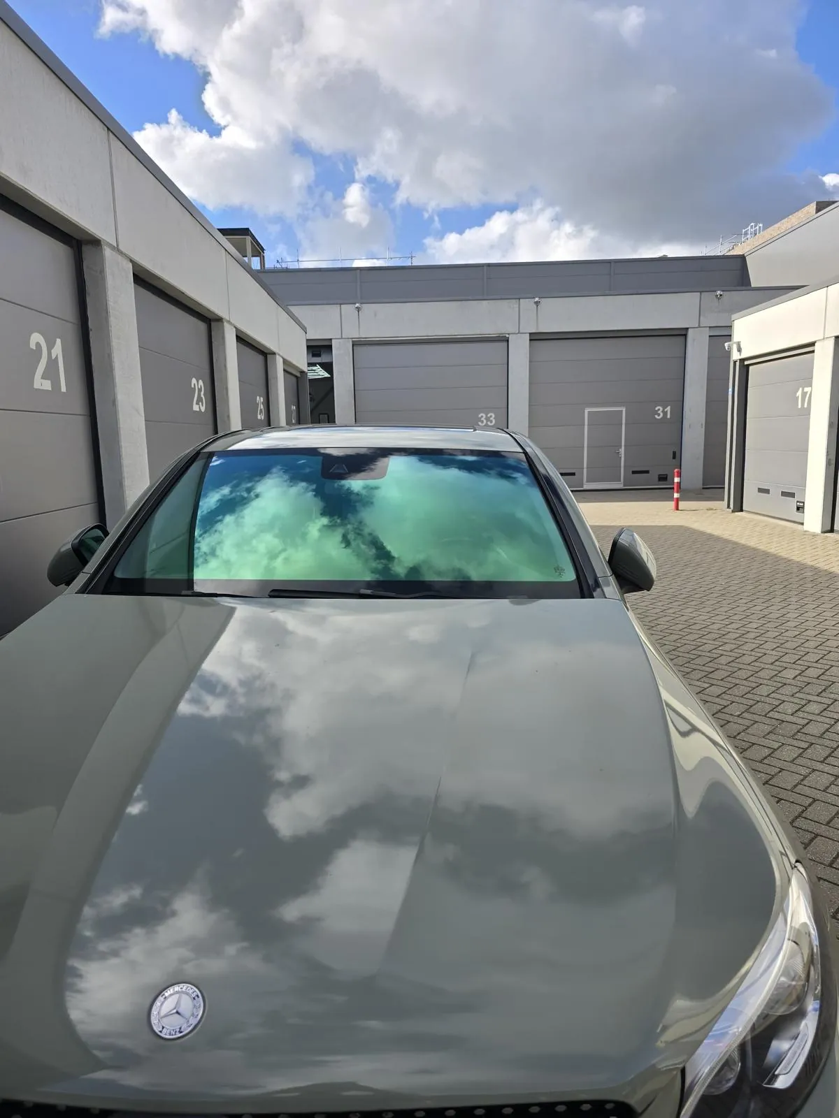 Grijze auto met groen reflecterende chameleon voorruitfolie