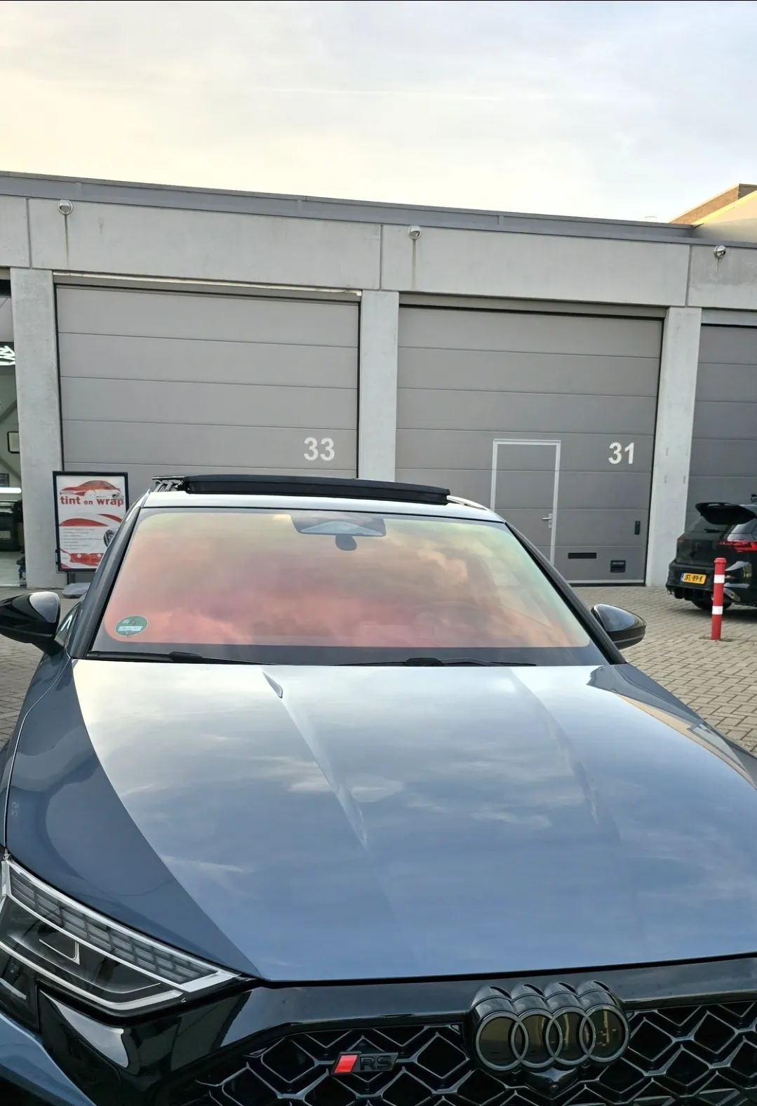 Grijze Audi met rood en goud reflecterende chameleon voorruitfolie