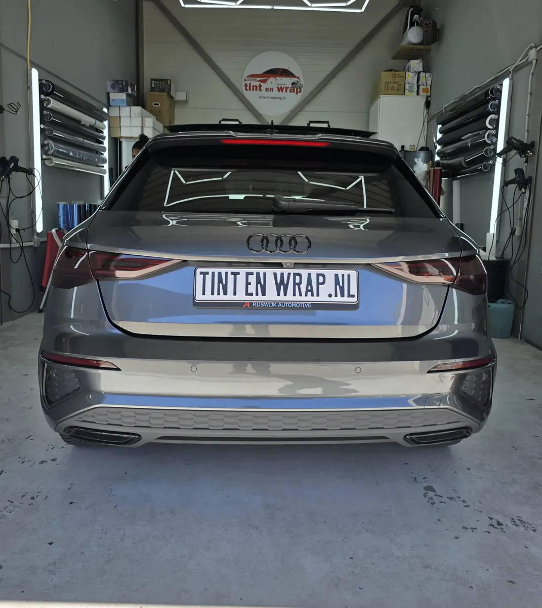 Grijze Audi A3 met getinte achterruit en TINT EN WRAP.NL-bord