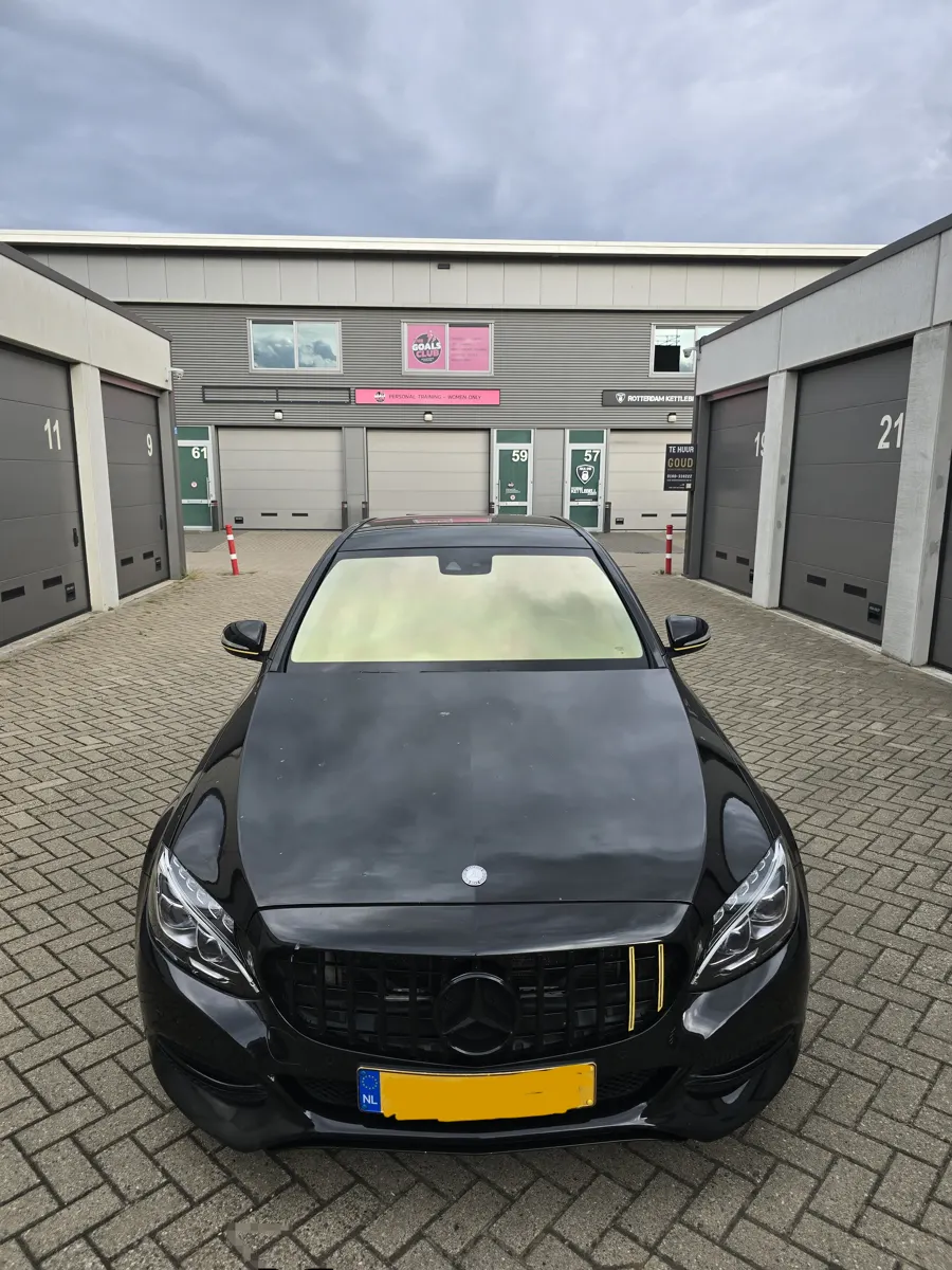 Zwarte Mercedes met getinte voorruit voor de werkplaatsboxen