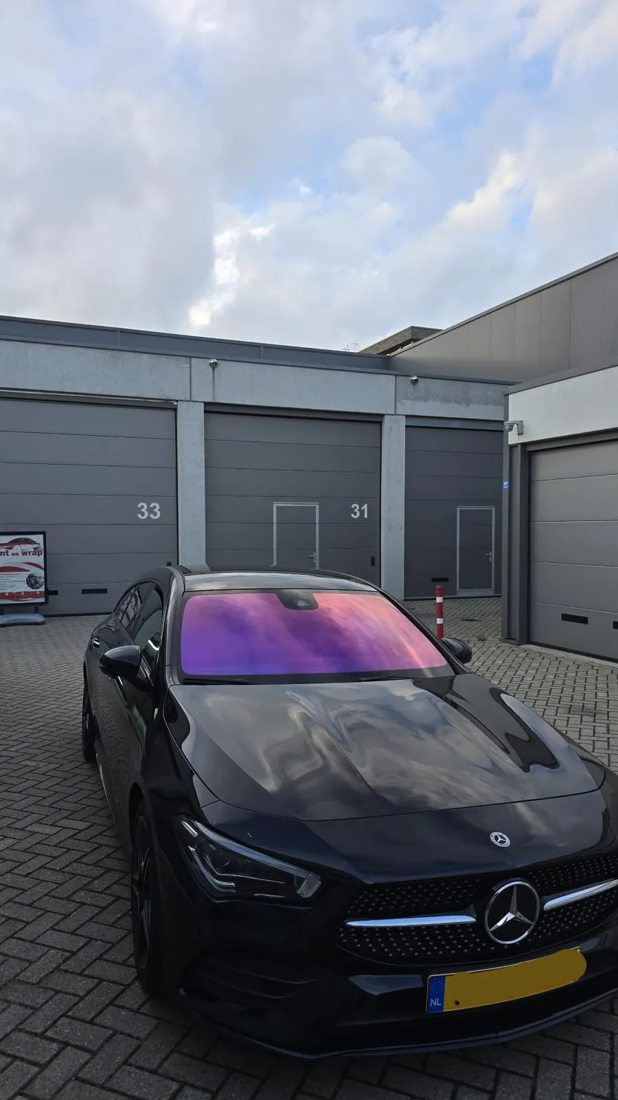 Zwarte Mercedes met paars reflecterende chameleon folie op de voorruit