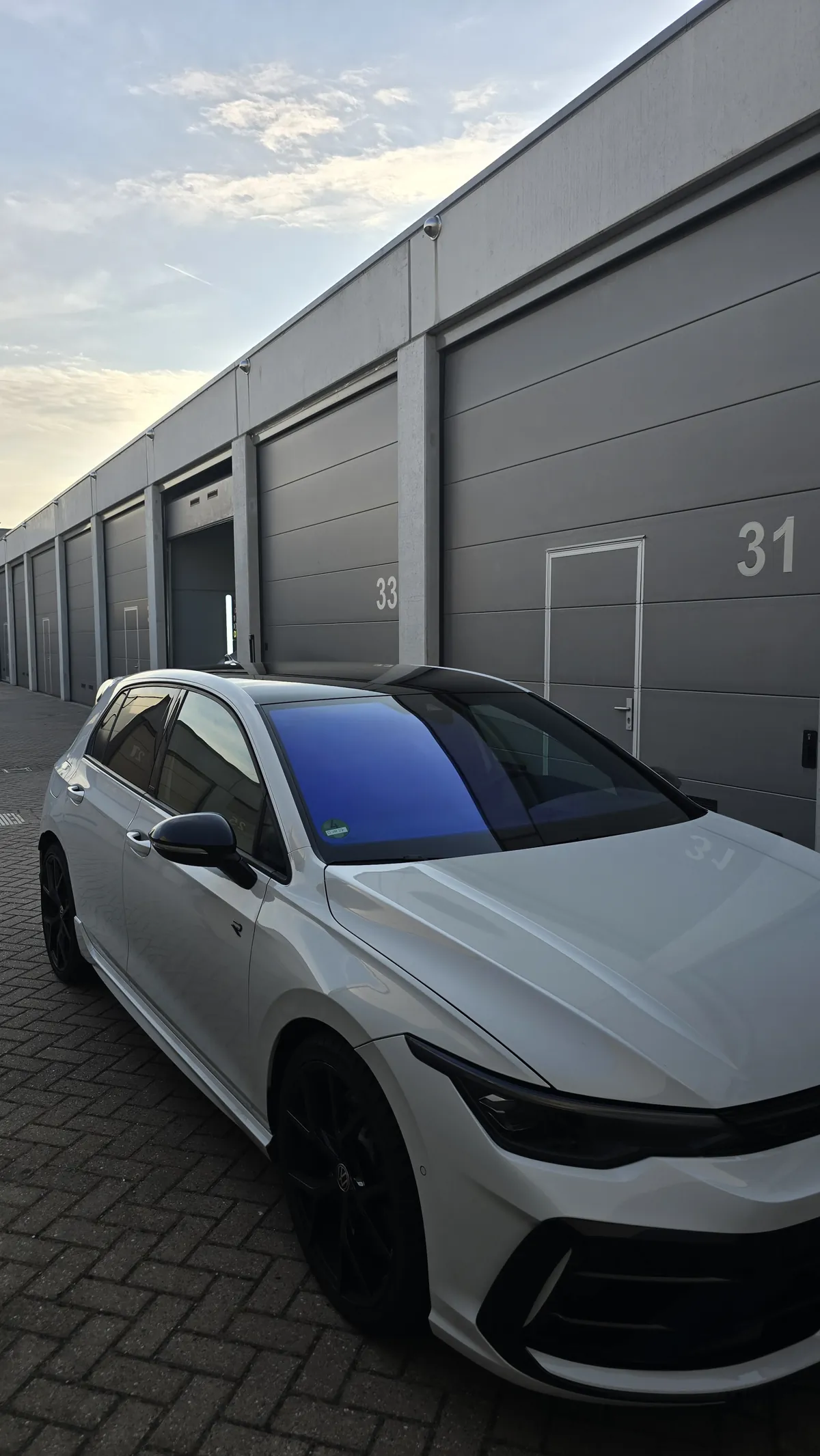 Witte Volkswagen met blauw reflecterende chameleon voorruitfolie