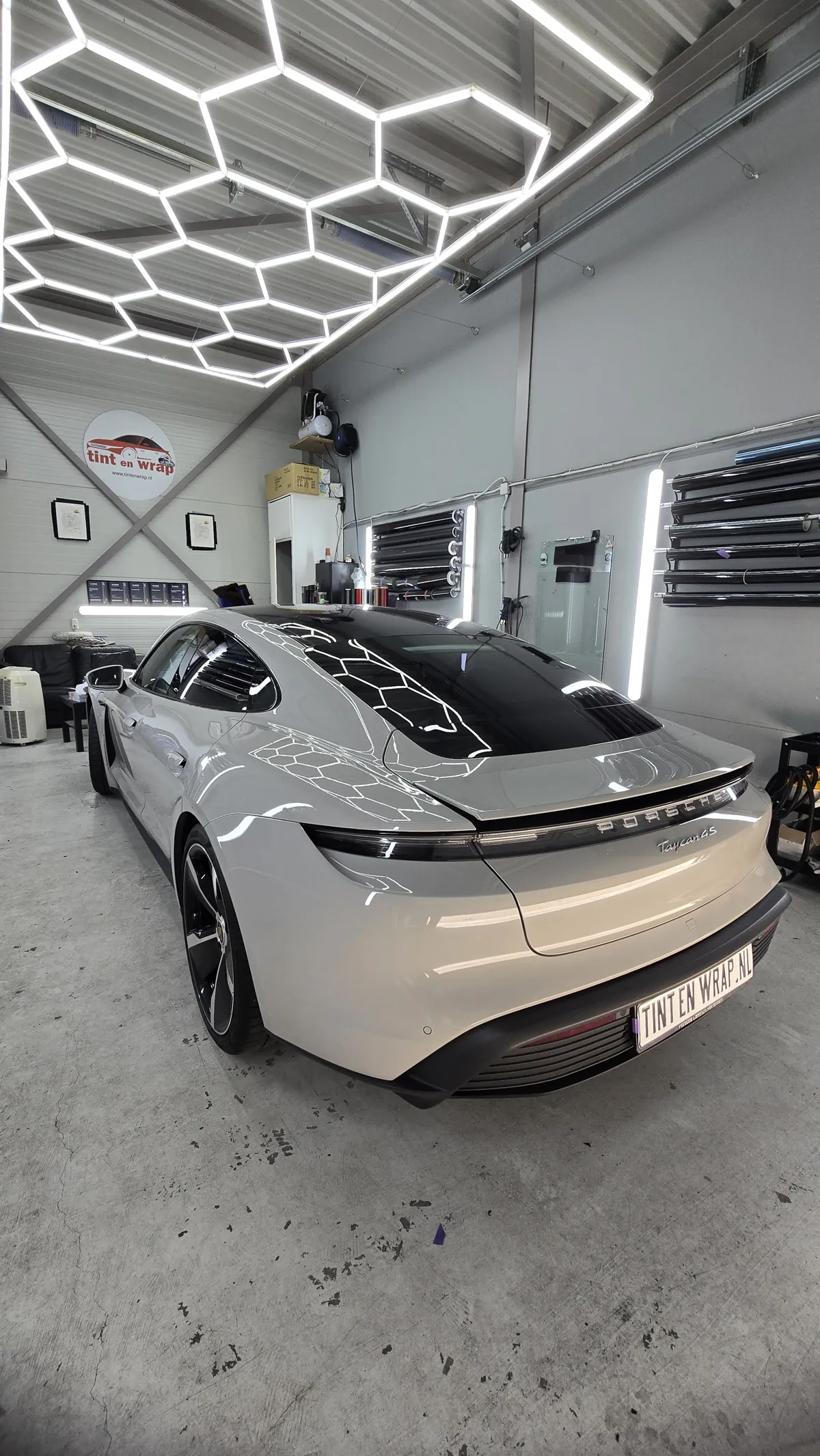 Witte auto met donkere achterruit in de werkplaats van Tint En Wrap