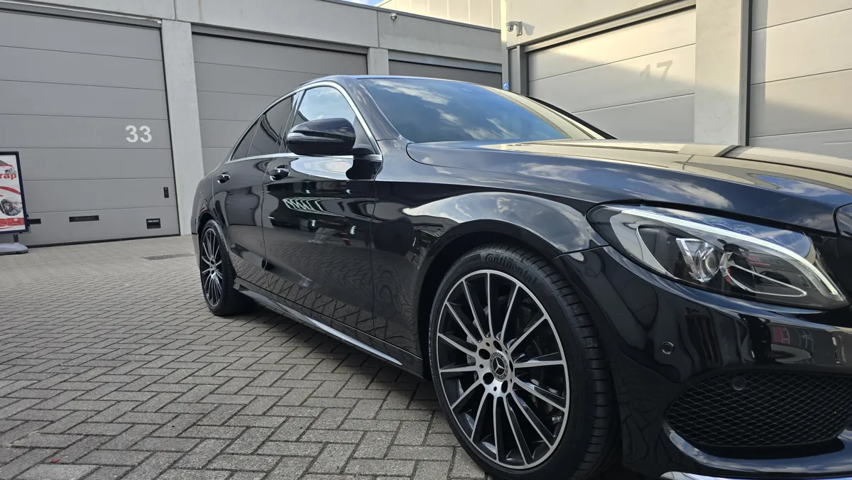 Zwarte Mercedes met getinte zijruiten, schuin van voren gefotografeerd