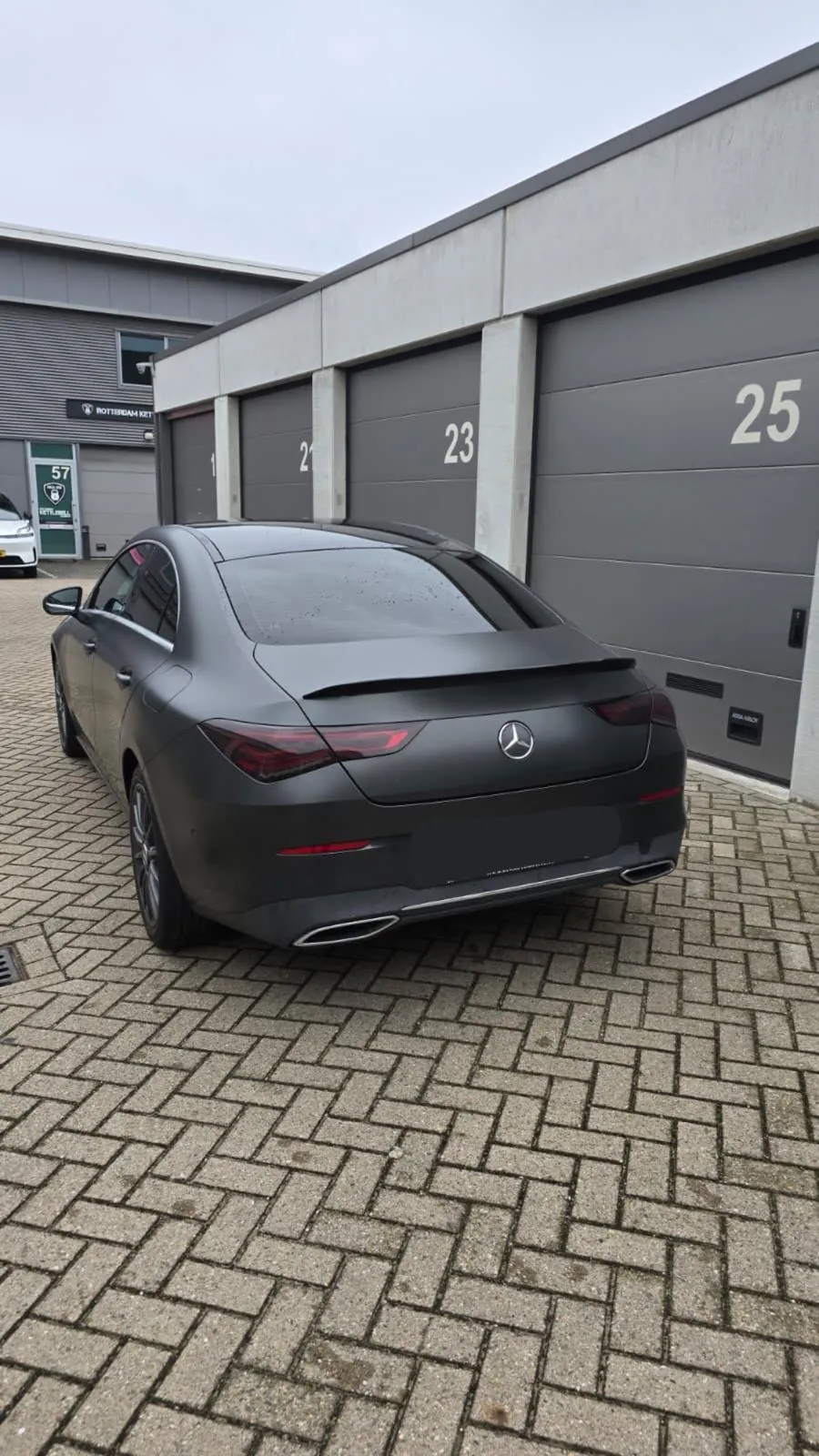 Donkere Tesla met geblindeerde achterruit, schuin van achteren gefotografeerd