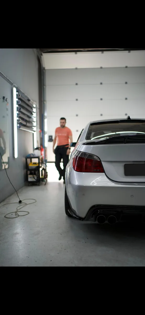 Zilvergrijze BMW M5 met donkere ruiten in de werkplaats