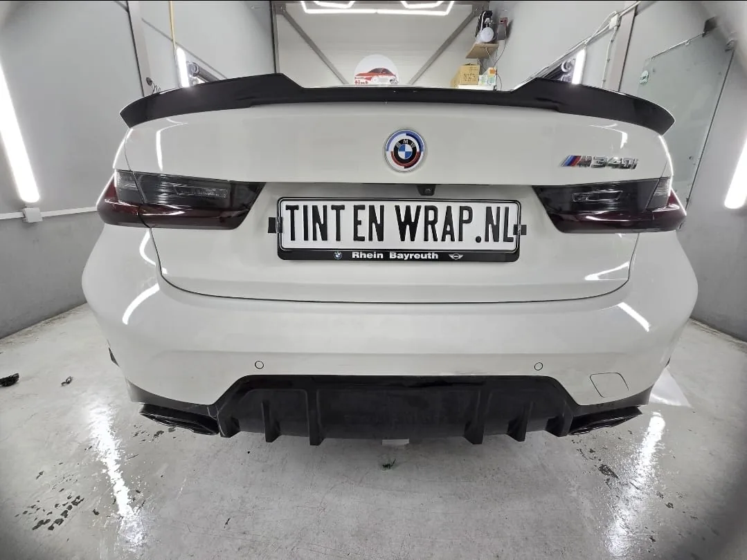 Witte BMW met gesmokte achterlichten en donkere achterruit